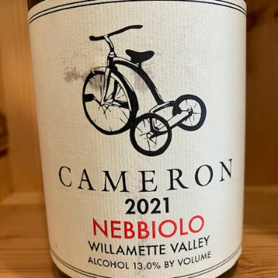 Wine bottle label with 'Cameron' branding and bicycle graphic on a wooden surface